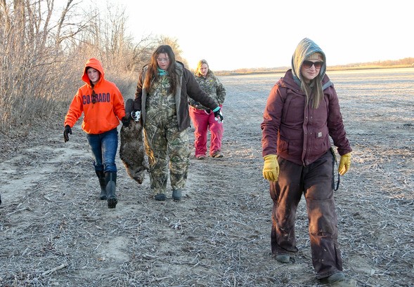 Trenton High School Ag students carry a trapped beaver