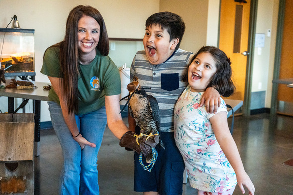 falconer with falcon and two kids