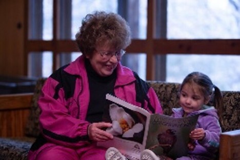 Grandmother reads to granddaughter
