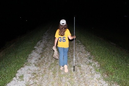 person with frog gigging pole and net