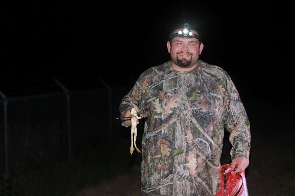 person holding gigged frog